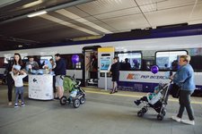 Stoisko promocyjne PKP Intercity na stacji Kraków Główny, pociąg PKP Intercity, uczestnicy wydarzenia.