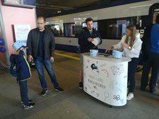 Stoisko promocyjne PKP Intercity na stacji Kraków Główny, pociąg PKP Intercity, uczestnicy wydarzenia.