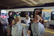 Stoisko promocyjne PKP Intercity na stacji Kraków Główny, pociąg PKP Intercity, uczestnicy wydarzenia.